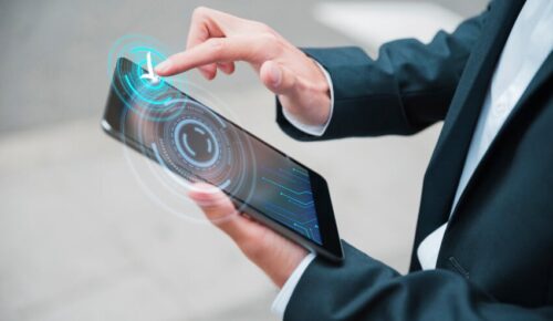 Businessperson touching tablet with holographic interface