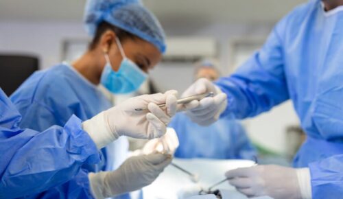 Surgical team passing instruments in operating room