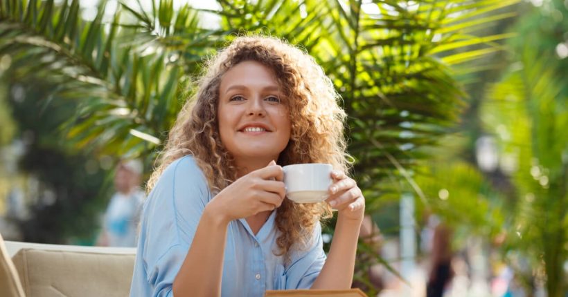 Smiling woman enjoying coffee outdoors