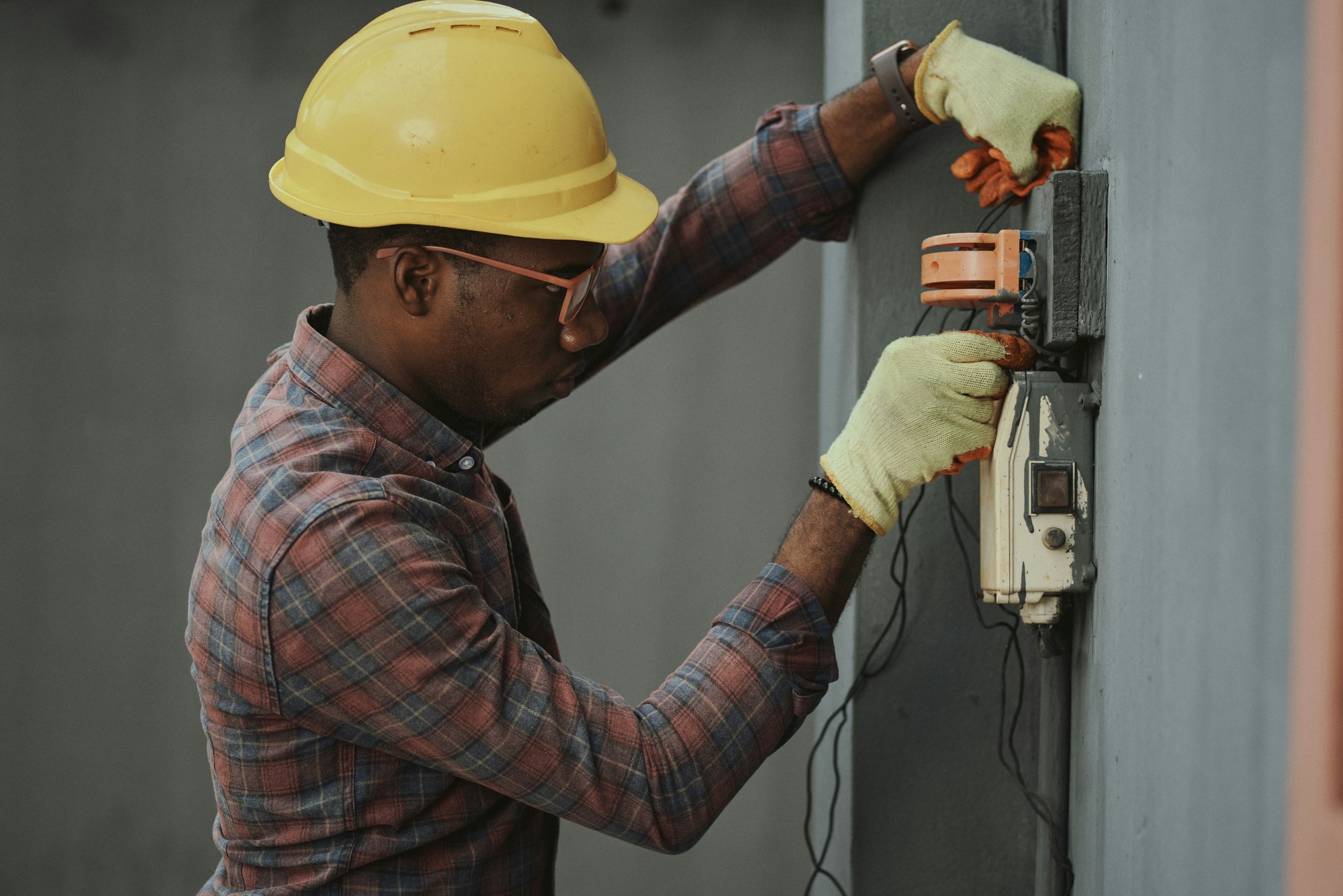 Electrician testing wall outlet with multimeter