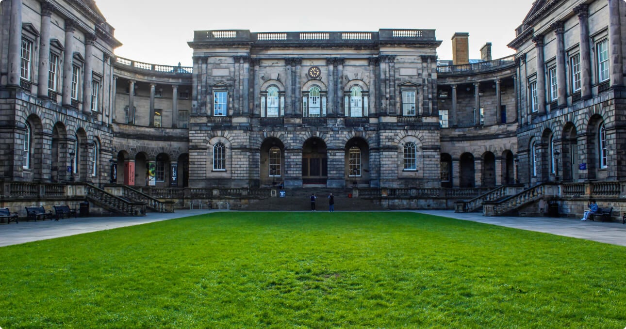 Historic stone building with curved courtyard lawn