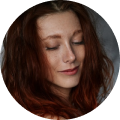 Person with red hair, eyes closed, smiling