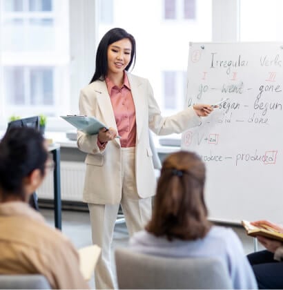 Teacher pointing at whiteboard teaching students