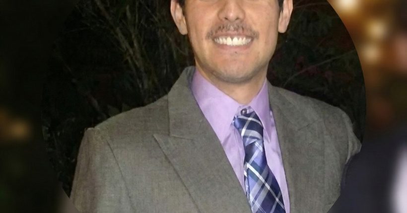 Smiling person wearing gray suit and tie
