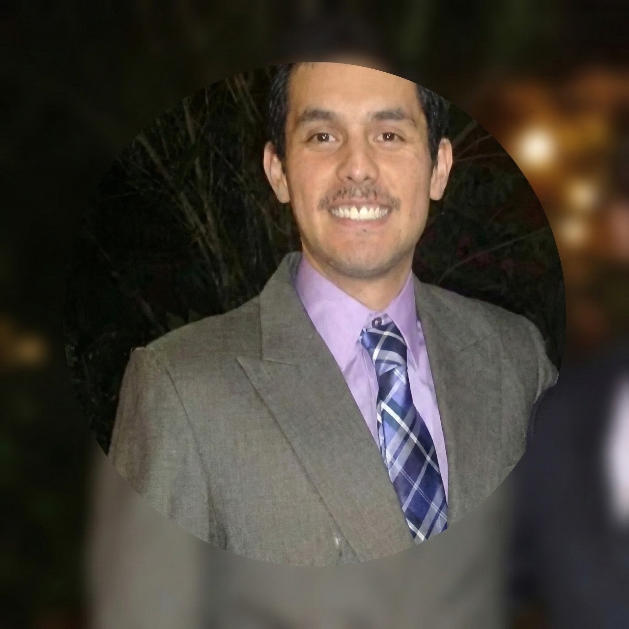 Smiling person wearing gray suit and tie